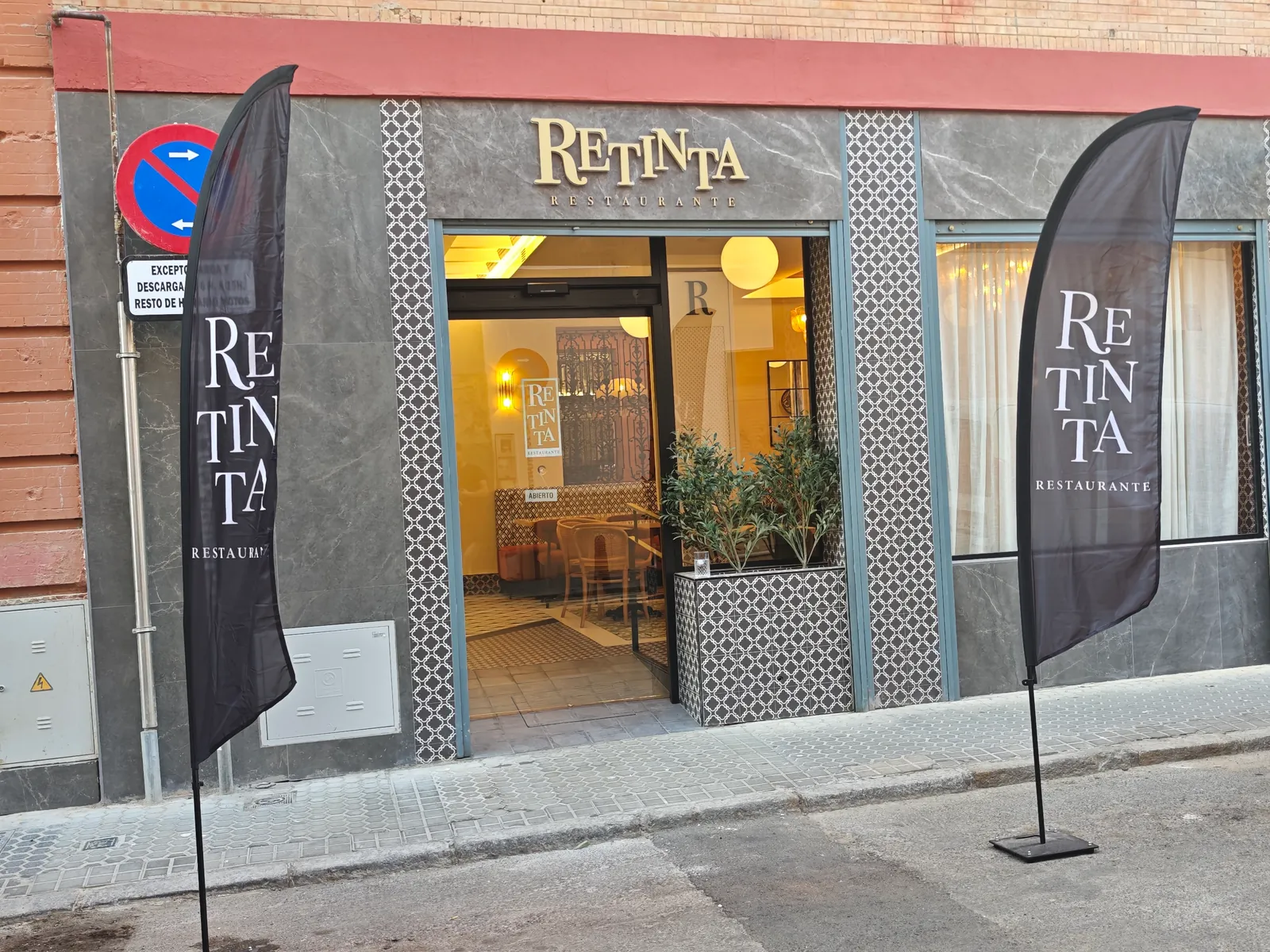 Trabajo real de banderas publicitarias en la fachada de un restaurante