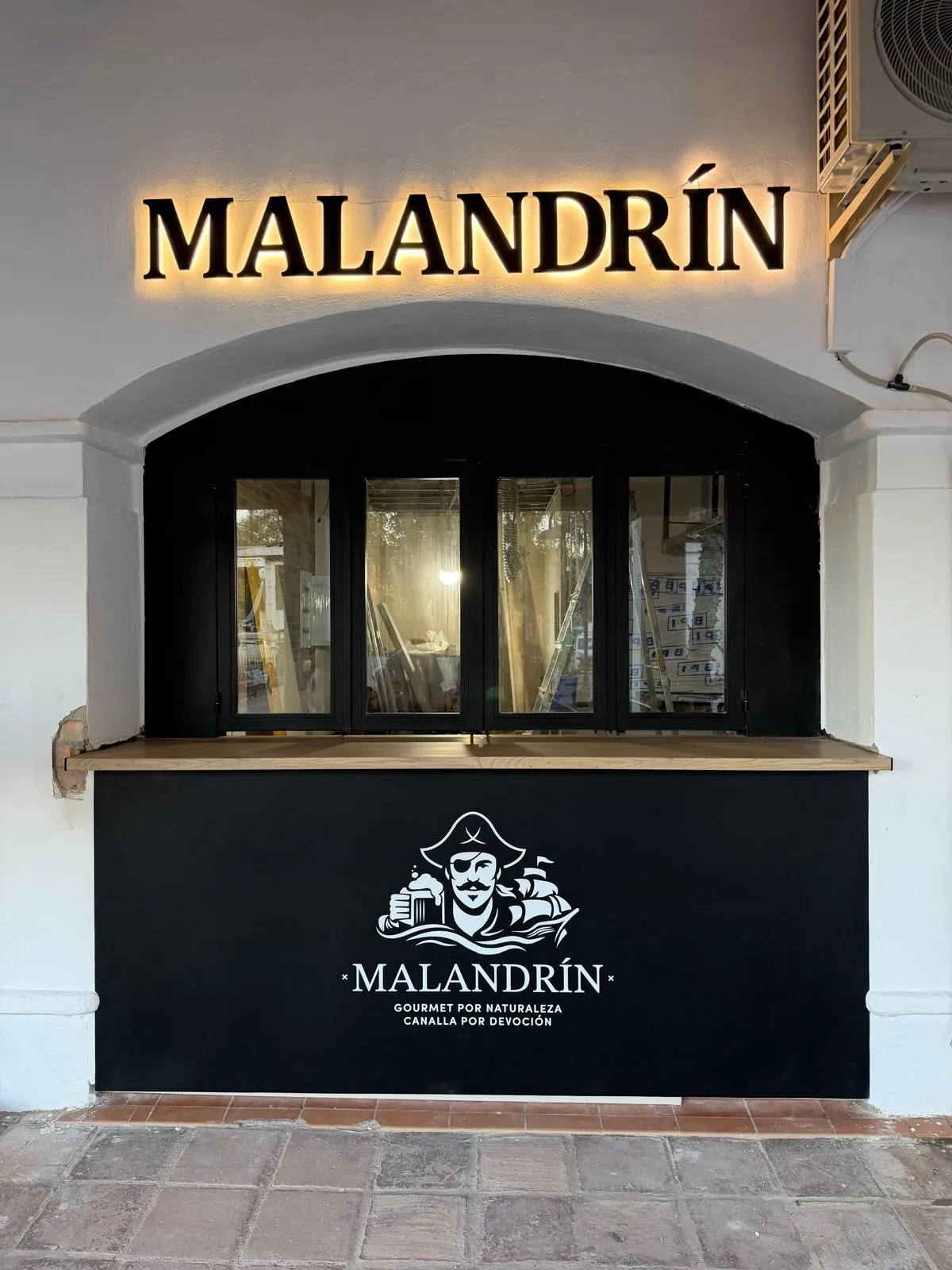 Trabajo real de letras corpóreas retroiluminadas en la fachada de un bar