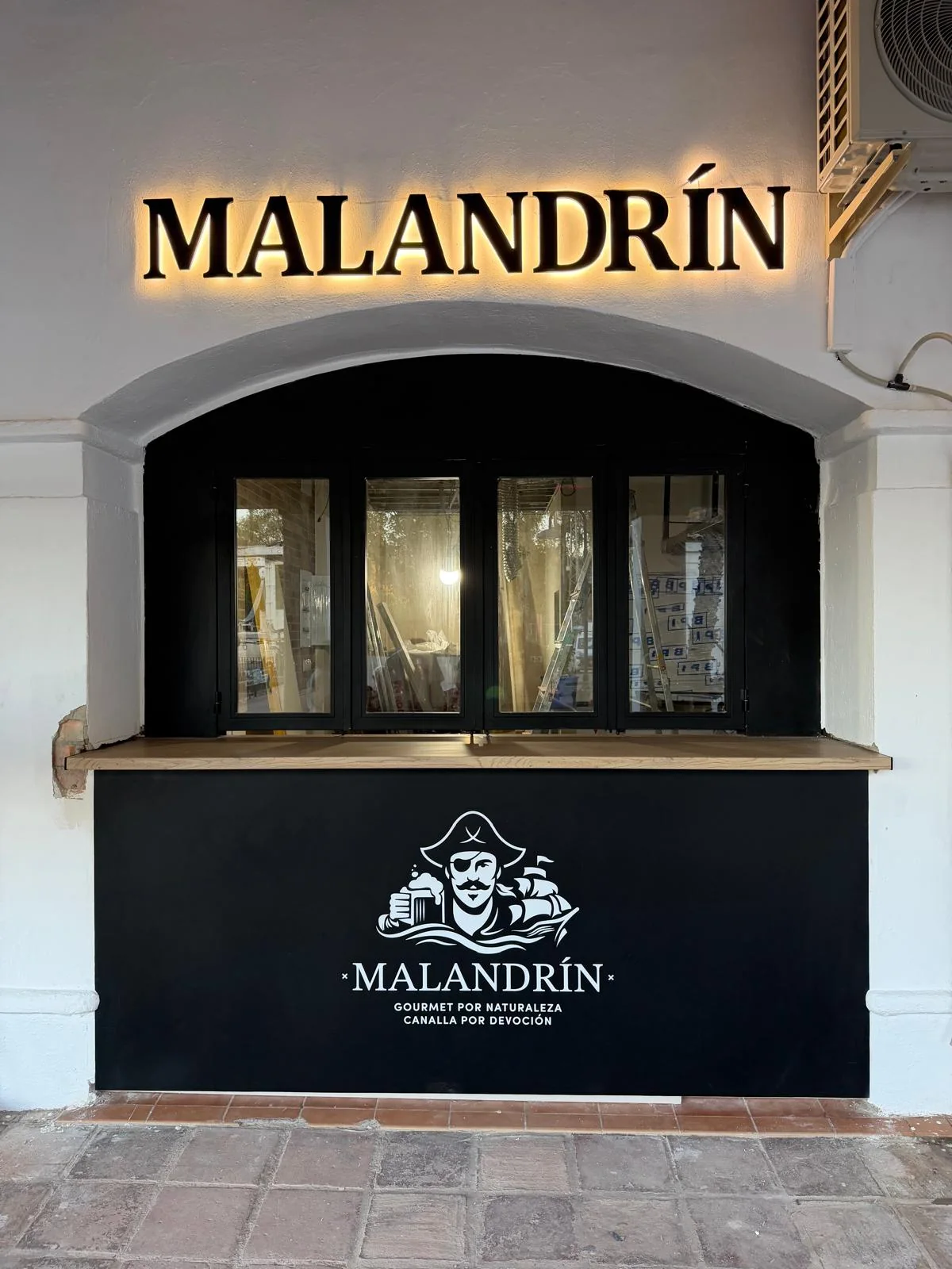 Letras corpóreas de Malandrín con retroiluminación sobre la ventana del local.